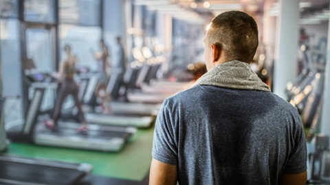 achterkant bezwete rug van man in de sportschool die wilt afvallen